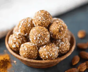 No-Bake Pumpkin Pie Energy Balls topped with crushed nuts and cinnamon on a plate, healthy fall snack, festive dessert bites