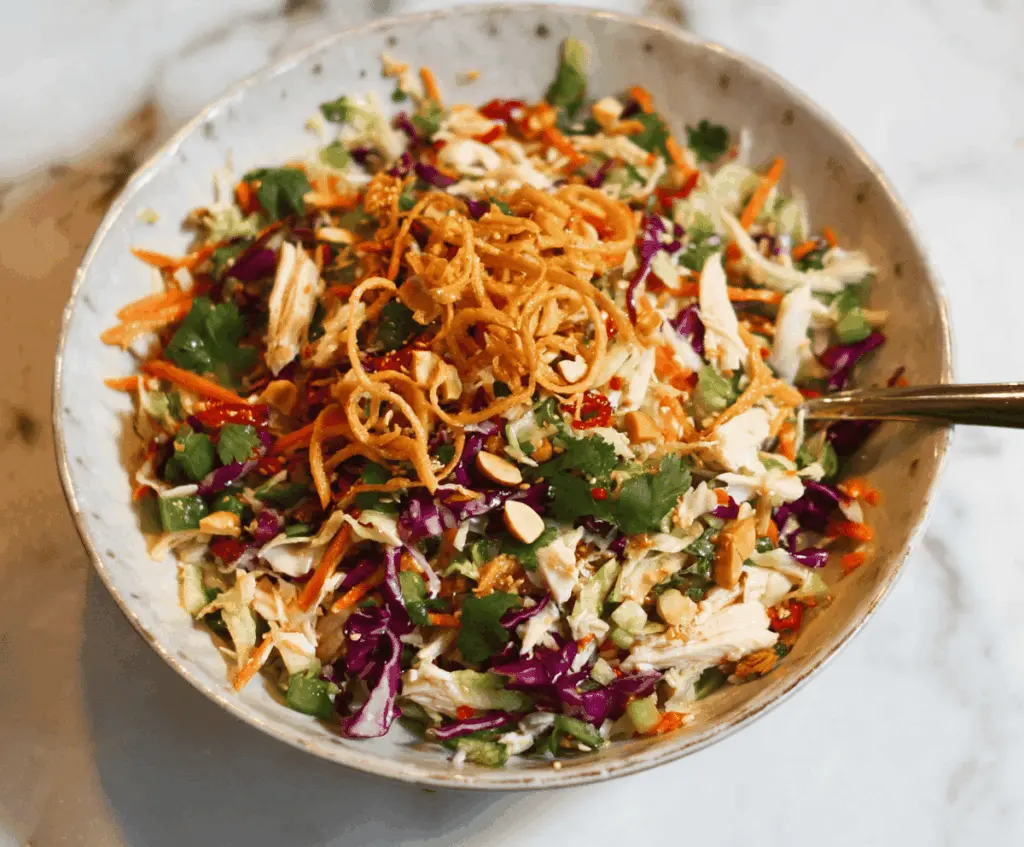Fresh and colorful Crunchy Chinese Chicken Salad with crispy chicken strips, vibrant vegetables, and sesame seeds in a bowl