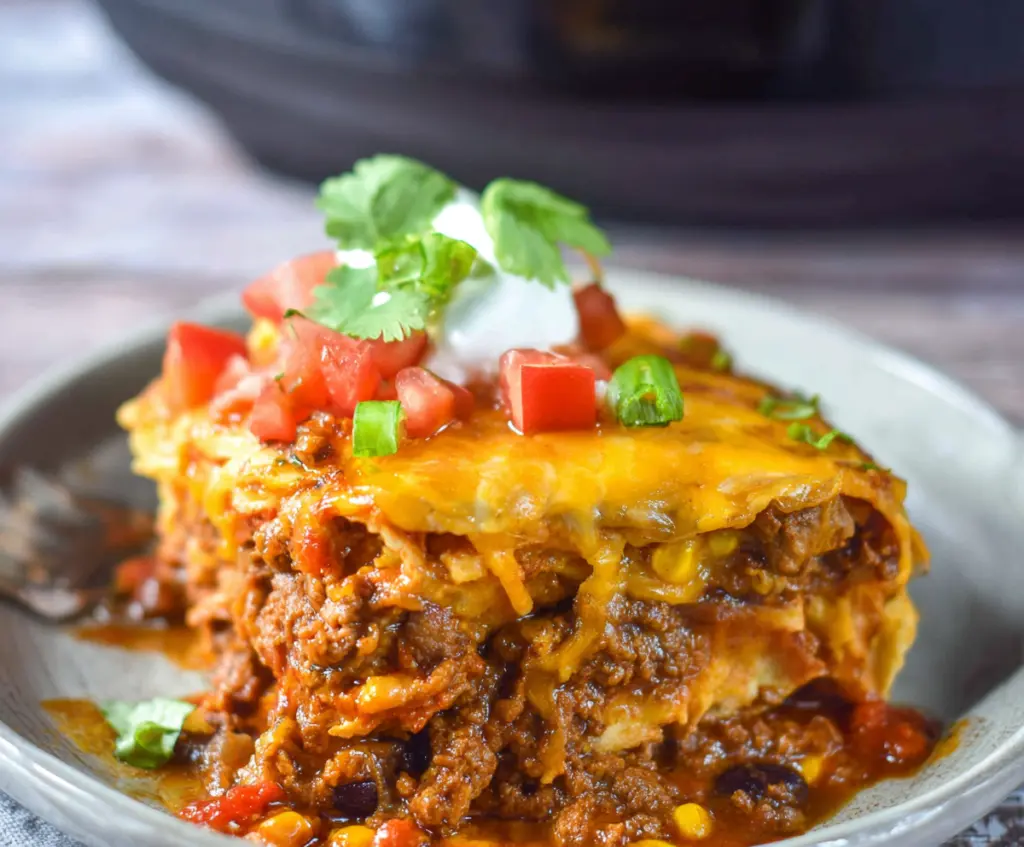 Delicious Crockpot Beef Enchilada Casserole with melted cheese and seasoned beef in a baking dish.